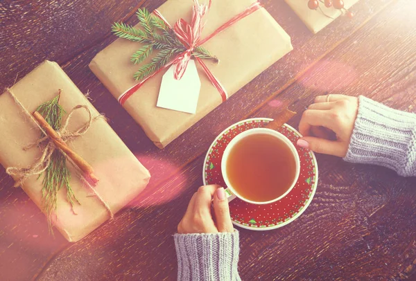 Femme assise sur le bureau avec boîte cadeau de Noël. Mains de femme — Photo