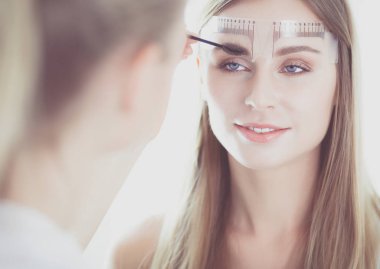 Kaşlar için kalıcı makyaj. Güzellik salonunda kalın kaşlı güzel bir kadın..