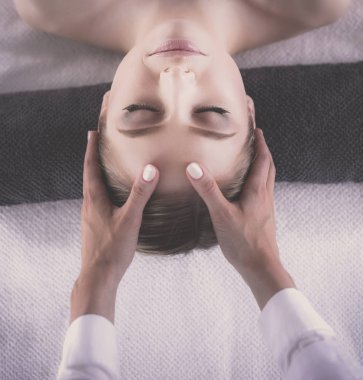 Masaj masasında uzanmış gözleri kapalı rahatlayan genç bir kadın. - Kadın. Spa salonu