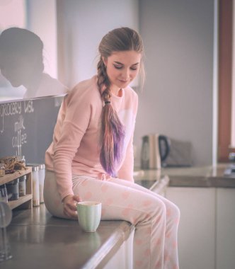 Mutfakta masada oturan genç kadın