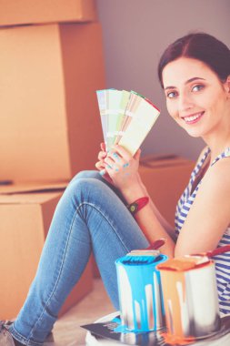 Kadın seçerek boya rengi renk örneği yeni ev ahşap yere oturmak için. Kadın evde