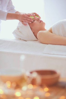 Masaj masasında uzanmış gözleri kapalı rahatlayan genç bir kadın. - Kadın. Spa salonu