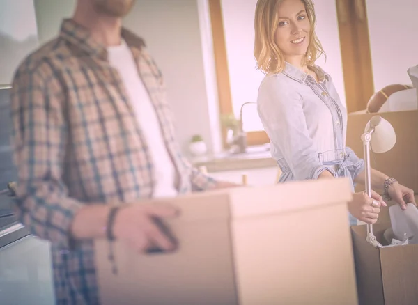 Couple unpacking cardboard boxes in their new home. Young couple. — Stock Photo, Image