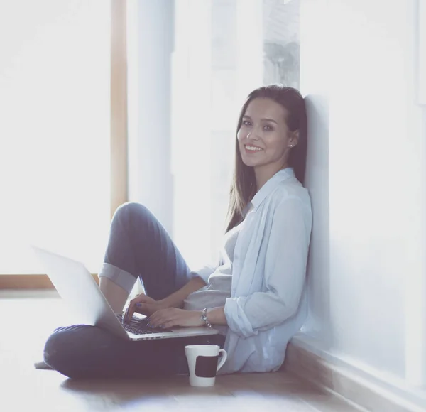 Jovem mulher bonita em casa sentado no chão com laptop. Jovem mulher bonita . — Fotografia de Stock