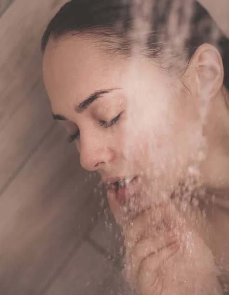 Junge schöne Frau unter der Dusche im Badezimmer. — Stockfoto