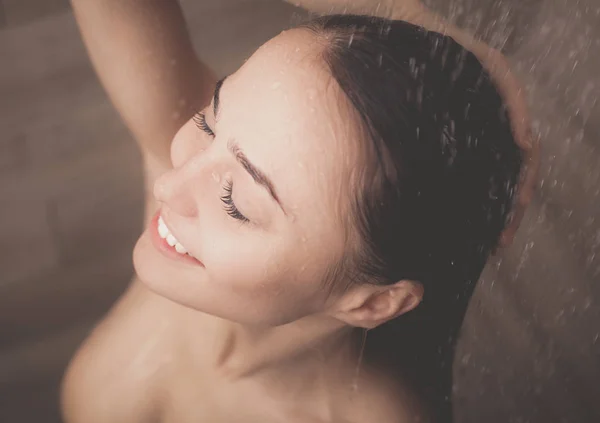 Junge schöne Frau unter der Dusche im Badezimmer. — Stockfoto