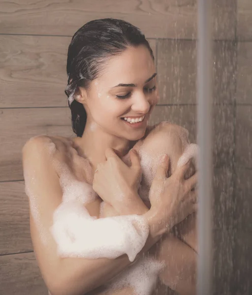 Jeune femme belle sous la douche dans la salle de bain . — Photo