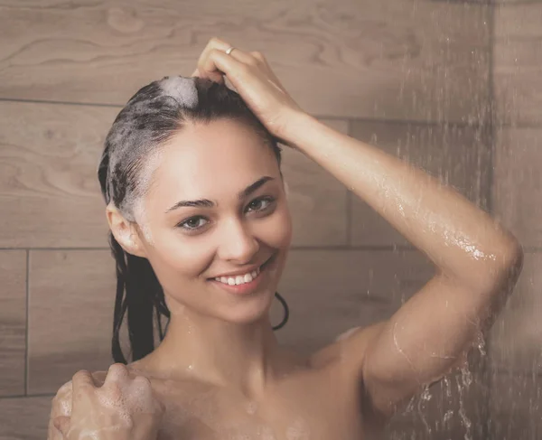 Jonge beautyful vrouw onder de douche in de badkamer. — Stockfoto