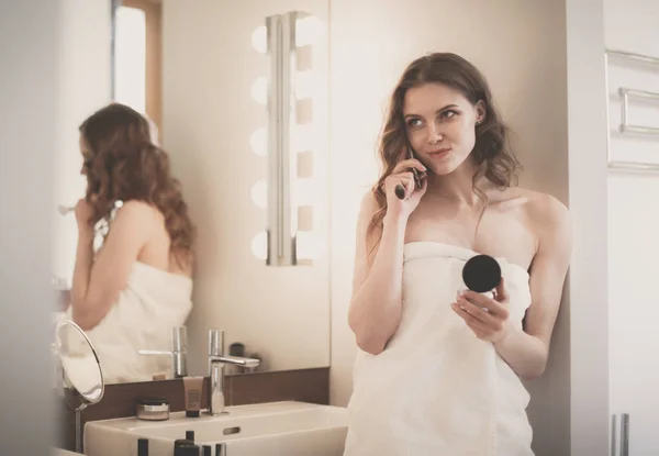 Młoda kobieta stojąc na telefon w łazience. — Zdjęcie stockowe