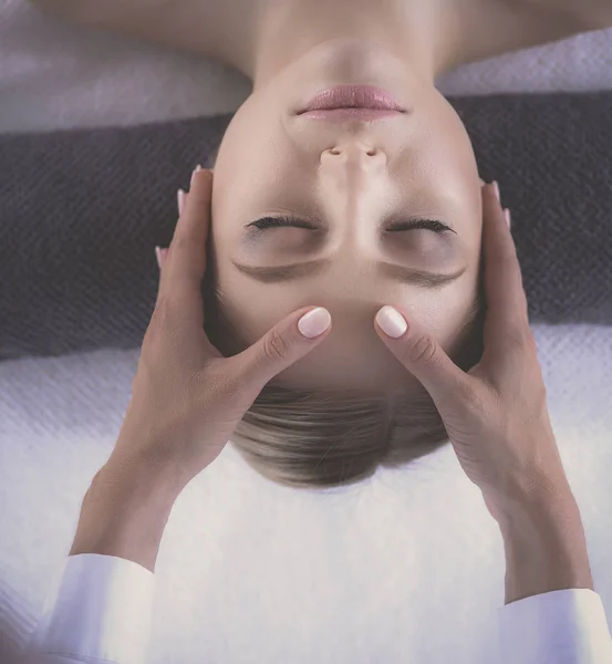 Ung kvinna liggande på ett massagebord, avslappnande med slutna ögon. Kvinnan. Spasalong — Stockfoto