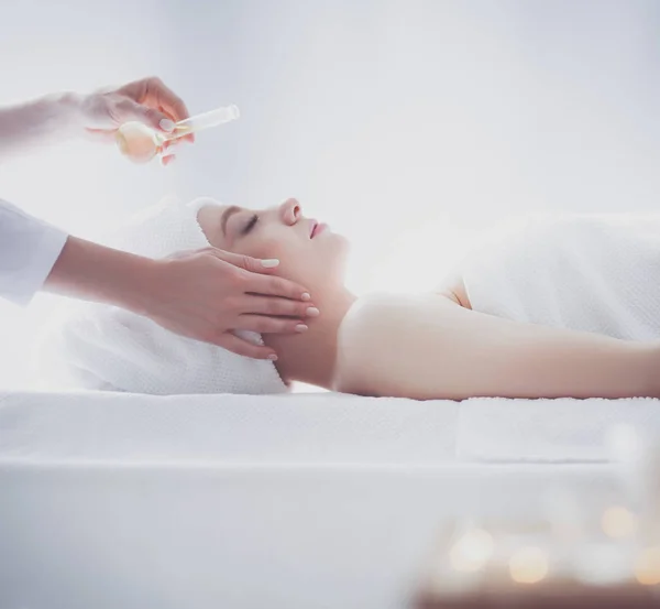 Jovem deitada em uma mesa de massagem, relaxando com os olhos fechados. Mulher. Salão de Spa — Fotografia de Stock