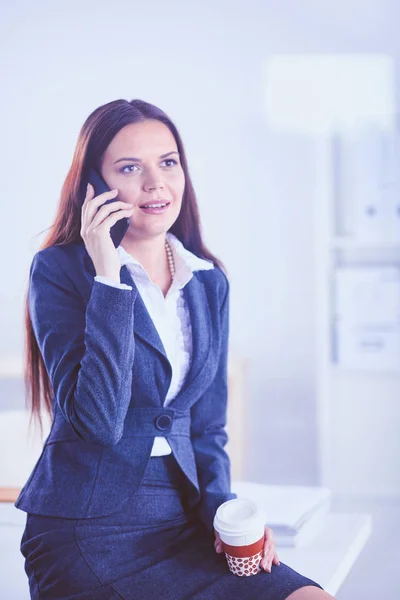 Una hermosa mujer de éxito hablando por teléfono en la oficina moderna. Una hermosa mujer de éxito — Foto de Stock