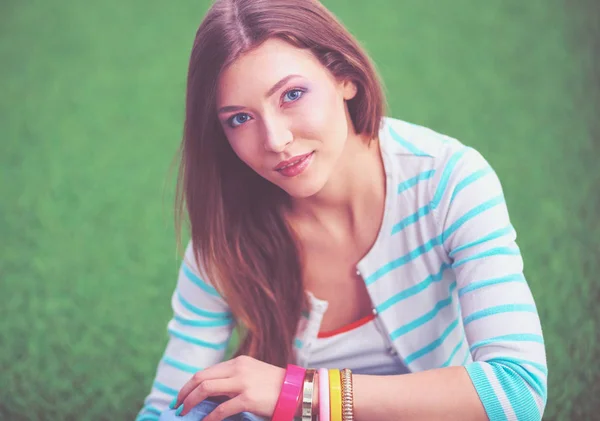 Una joven sentada sobre hierba verde. Portreit mujer joven — Foto de Stock