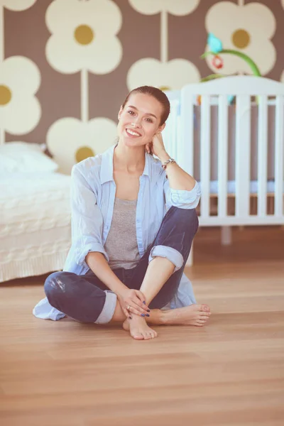 Jonge vrouw doet yoga thuis in de lotuspositie. Jonge vrouw doet yoga. — Stockfoto