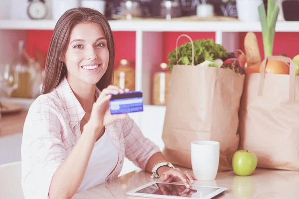 Young woman in the kitchen, using her ipad. Young woman — Stock Photo, Image