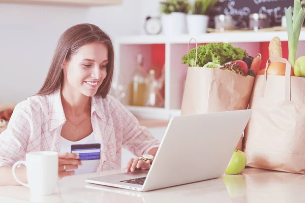 Smiling woman online shopping using tablet and credit card in kitchen . Smiling woman — Stock Photo, Image