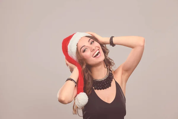 Gülümseyen bir Noel Baba şapkası giyen güzel bir kadın portresi. — Stok fotoğraf
