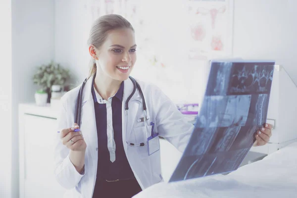Junge attraktive Ärztin betrachtet Röntgenbild — Stockfoto
