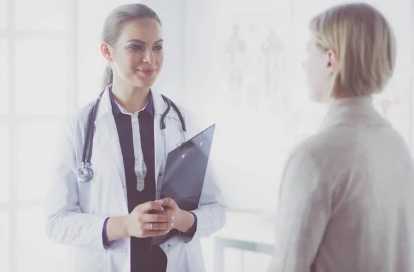 Arzt und Patient diskutieren etwas, während sie am Tisch sitzen. Medizin und Gesundheitskonzept — Stockfoto