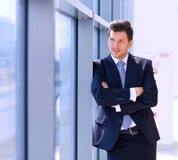 Portrait of businessman standing near window in office — Stock Photo, Image