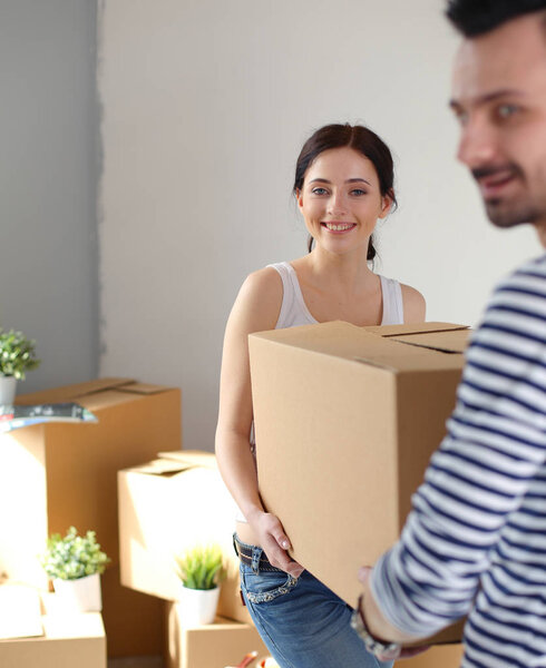 Счастливая молодая пара распаковывает или упаковывает коробки и переезжает в новый дом. молодая пара
