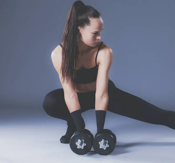 Mujer atlética bombeando músculos con mancuernas —  Fotos de Stock