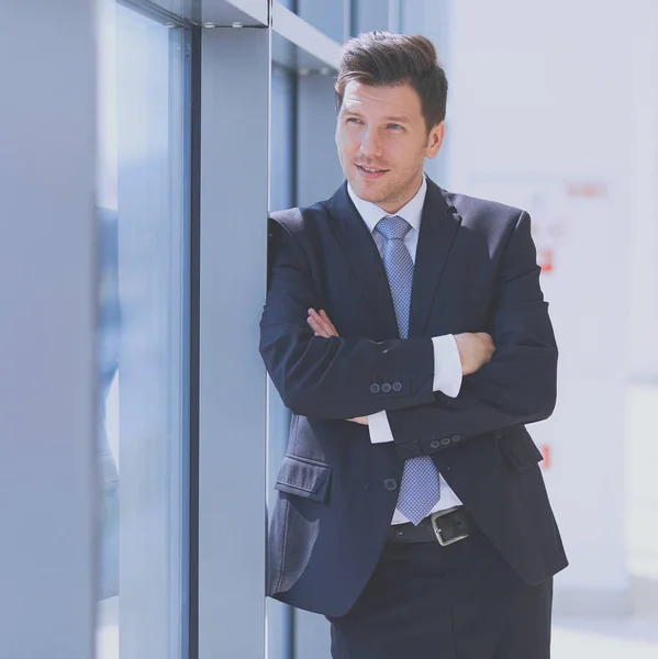 Retrato del hombre de negocios de pie cerca de la ventana en la oficina —  Fotos de Stock