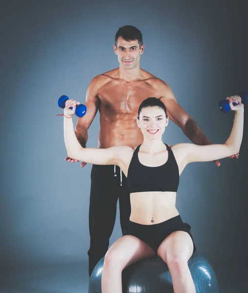 Dos personas sonrientes con pelota de fitness en el gimnasio. Instructor de fitness personal. Entrenamiento personal. Entrenamiento en el gimnasio . —  Fotos de Stock