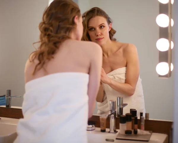 鏡を見て化粧をしている若い女性は. — ストック写真