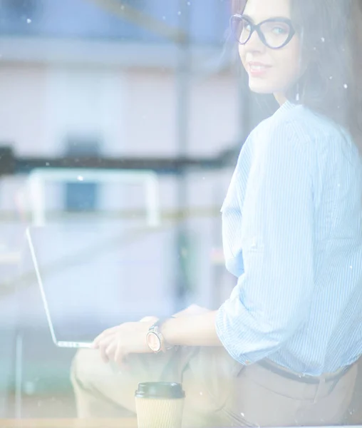 Mladá žena sedící u kancelářského stolu s laptopem, pohled oknem. Mladá žena — Stock fotografie