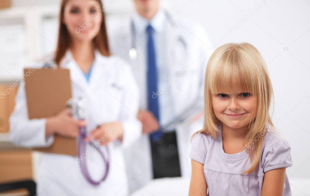 Female doctor examining child with stethoscope at surgery