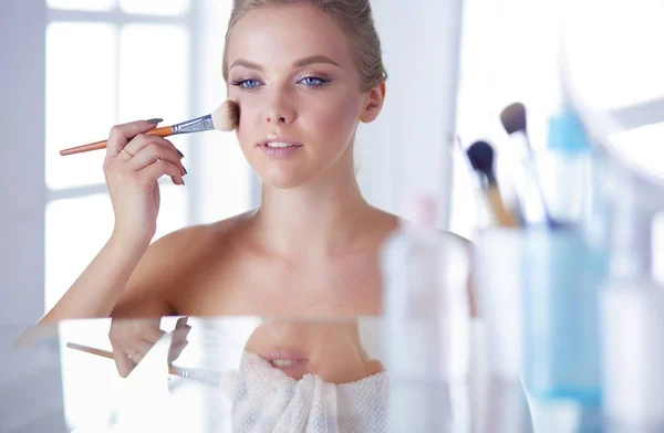 Genç bir kadının banyoya yüz pudrası sürerken fotoğrafı. — Stok fotoğraf