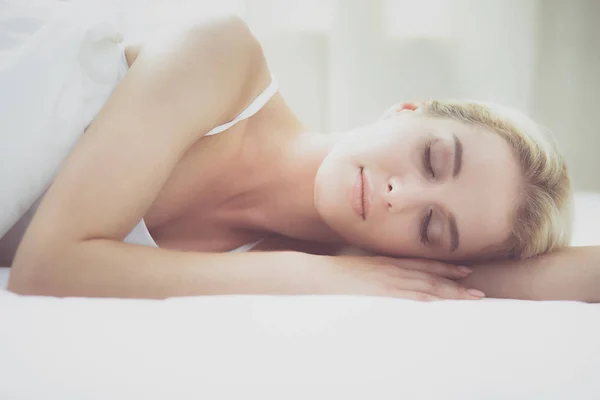 Hübsche Frau legt sich zu Hause auf ihr Bett — Stockfoto