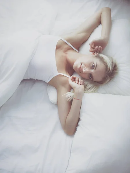 Красива жінка лежить на її ліжку вдома — стокове фото
