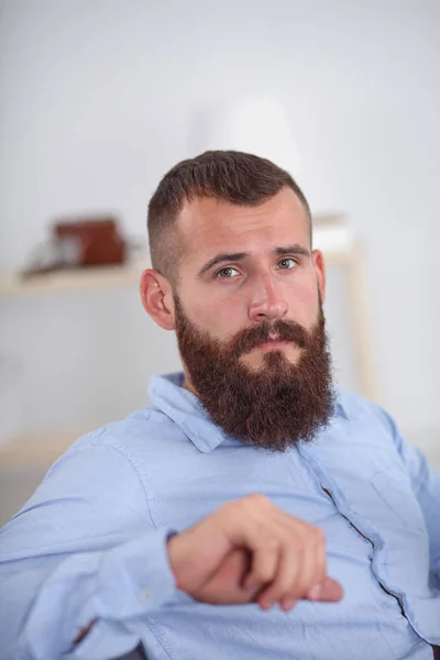 Young businessman sitting on chair in office — Stock Photo, Image