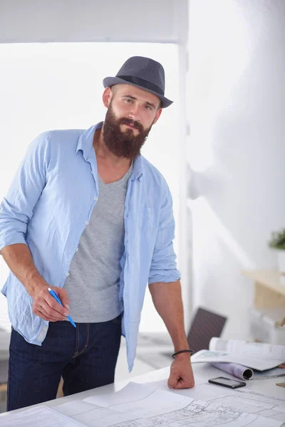 Portrait of male designer in hat with blueprints at desk — Stock Photo, Image