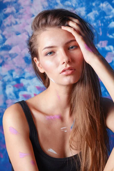 Young beautiful woman sitting near painting wall — Stock Photo, Image