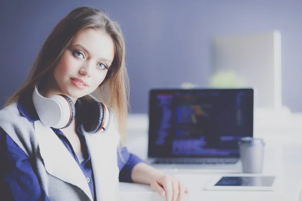 Ofis masasında çalışan ve dizüstü bilgisayarla yazan kendine güvenen genç bir iş kadını. — Stok fotoğraf
