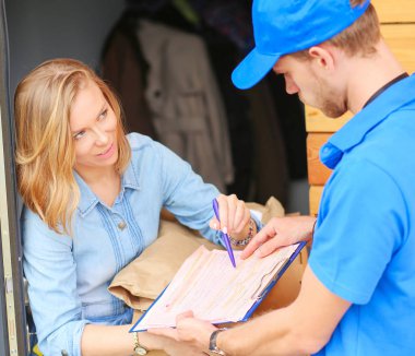 Mavi üniformalı gülümseyen kurye servis konseptine paket kutusu teslim eden teslimatçı. Mavi üniformalı gülümseyen teslimatçı.