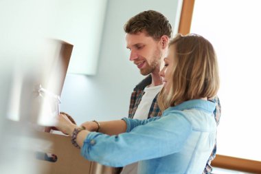 Genç bir çift yeni evde büyük karton kutu taşıyan. Ev taşıma. Genç Çift