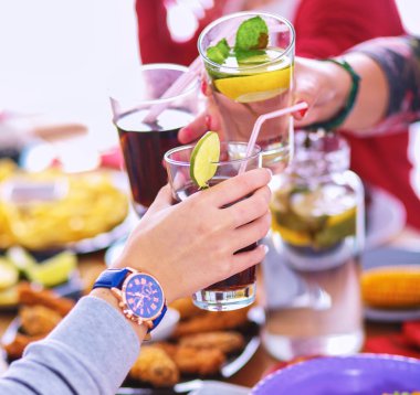 Yemek masasında içki içen insanlar.