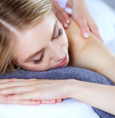 Masaj masasında uzanmış gözleri kapalı rahatlayan genç bir kadın. - Kadın. Spa salonu