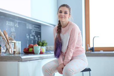 Mutfakta masada oturan genç kadın.