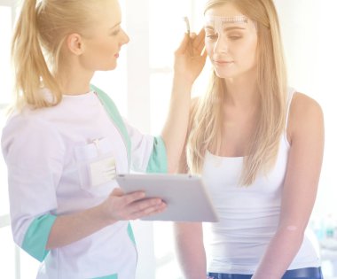 Kaşlar için kalıcı makyaj. Güzellik salonunda kalın kaşlı güzel bir kadın..