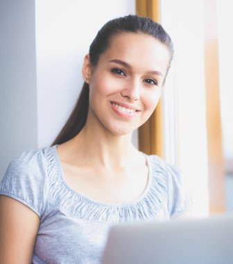 Evde bir dizüstü bilgisayar kullanan genç güzel kadın. Genç güzel kadın.