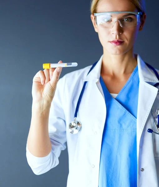 Female medical or research scientist or doctor using looking at a test tube of clear solution in a lab or laboratory. — Stock Photo, Image