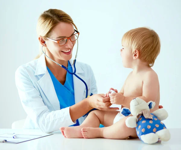 Vrouwelijke arts luistert kind met een stethoscoop in de kliniek — Stockfoto