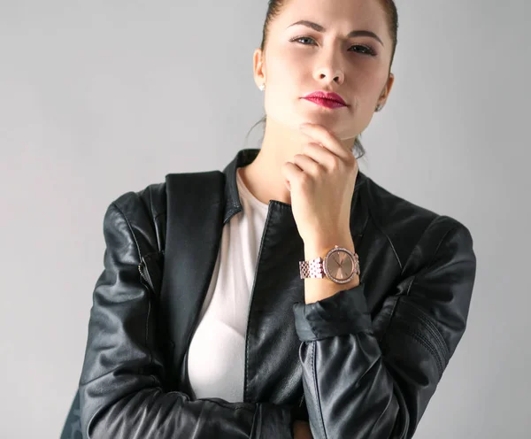Porträtt av vacker ung brunett kvinna i snygg svart jacka på grå. — Stockfoto