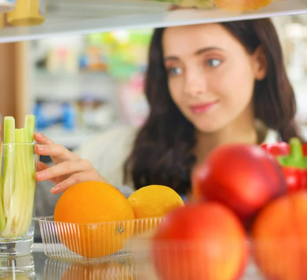 건강 한 음식, 야채, 과일들로 가득 찬 개방 된 냉장고 근처에 서 있는 여성의 모습. 여자의 모습 — 스톡 사진