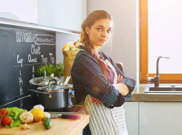 Krásná žena vaření dort v kuchyni stojí v blízkosti stolu — Stock fotografie